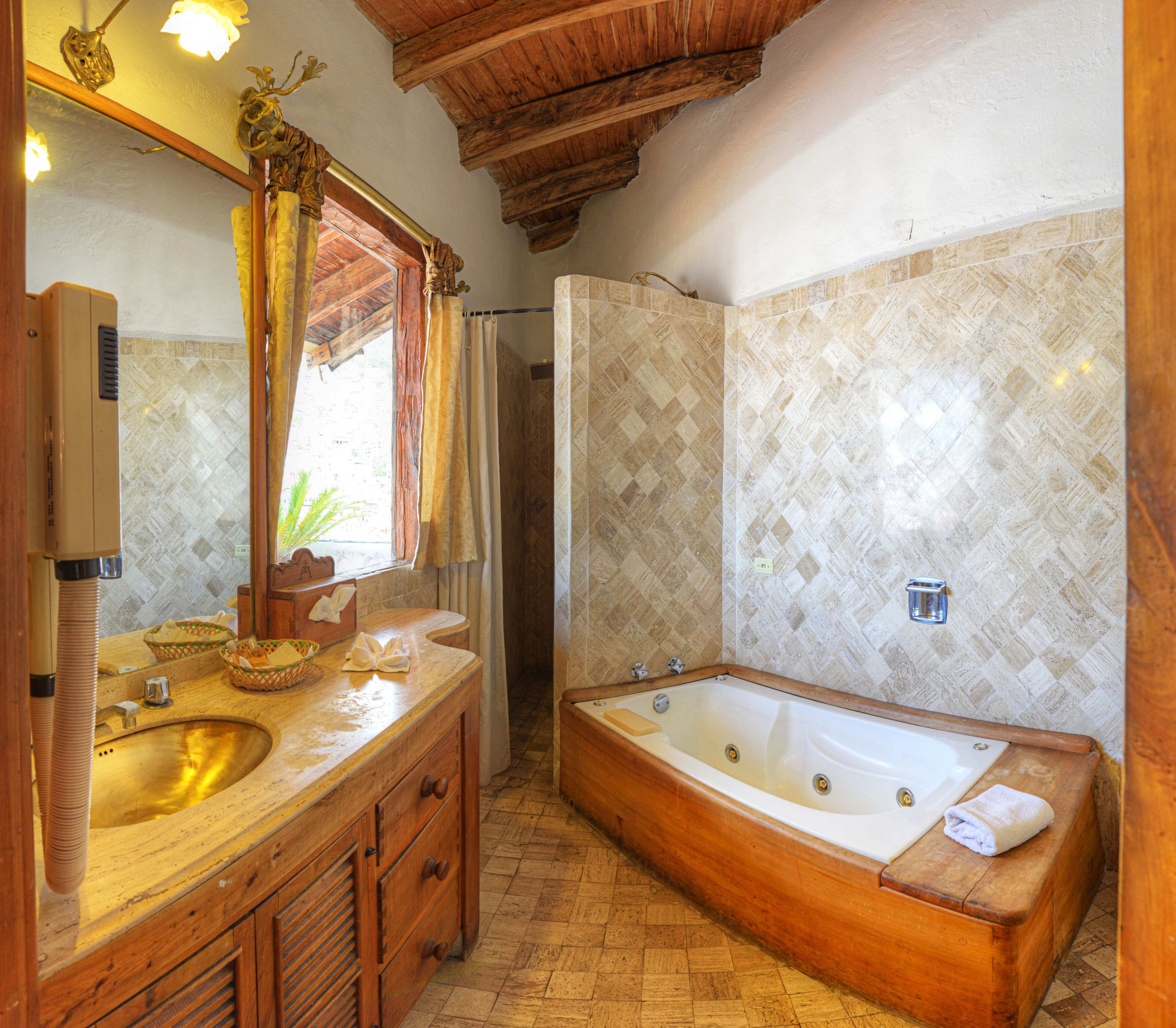 A bathroom with a wooden vanity, a large bathtub, and a shower area.