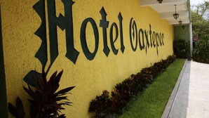 Keltainen seinä, jossa on suurin mustin kirjaimin kirjoitettu teksti: ”Hotel Oaxtepec”.