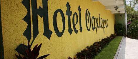 Parede amarela com o texto "Hotel Oaxtepec" em letras pretas grandes.
