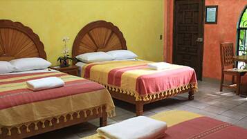 Two wooden beds with matching headboards, a small table with a chair, and a door with a window.