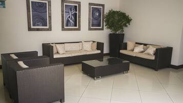A modern living room with two sofas, a coffee table, and a potted plant.