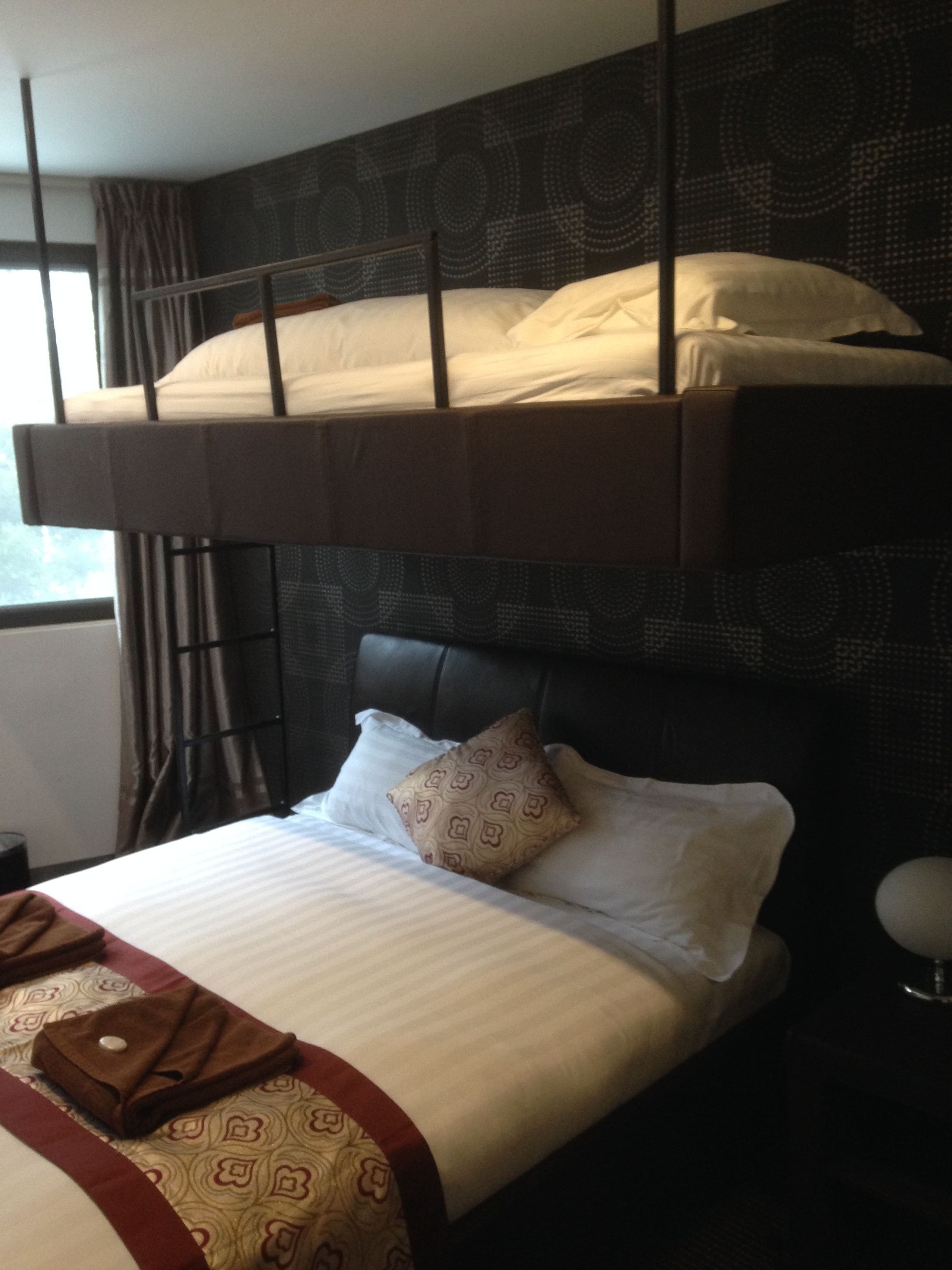 A bunk bed with a lower bed and a headboard with a patterned design.