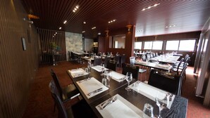 A restaurant with multiple dining tables, chairs, and a high ceiling with wooden slats. - Duck Inn Mt Buller (Mount Buller)