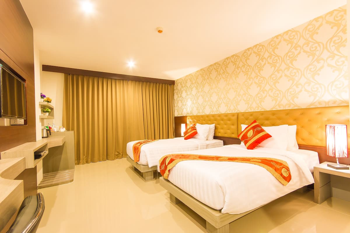 Une chambre d’hôtel avec deux lits, une télévision, un bureau et une salle de bain.