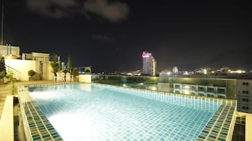 Una piscina al aire libre, sillones reclinables de piscina