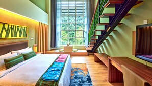 Una habitación de hotel moderna con una cama grande, un banco de madera, una escalera y un televisor.