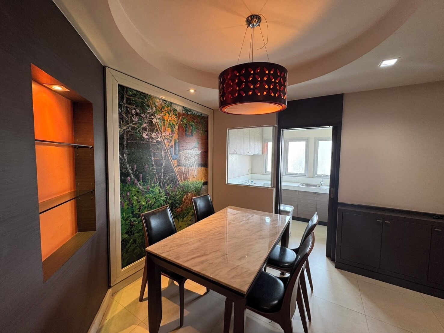 Un espace de repas moderne avec une table et des chaises en bois, une grande fresque murale et un luminaire suspendu au plafond.