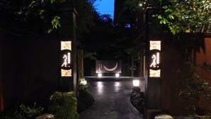 Un sendero conduce a un edificio con letreros iluminados y un símbolo de luna creciente.