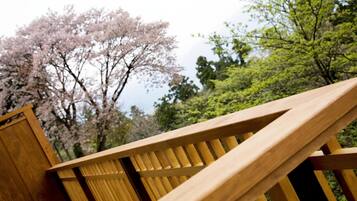 Una escalera de madera con vistas a árboles de cerezo en flor.