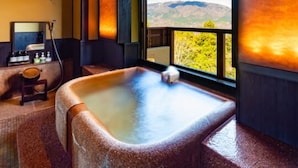 Un cuarto de spa con una bañera de hidromasaje, un espejo y vistas a las montañas.