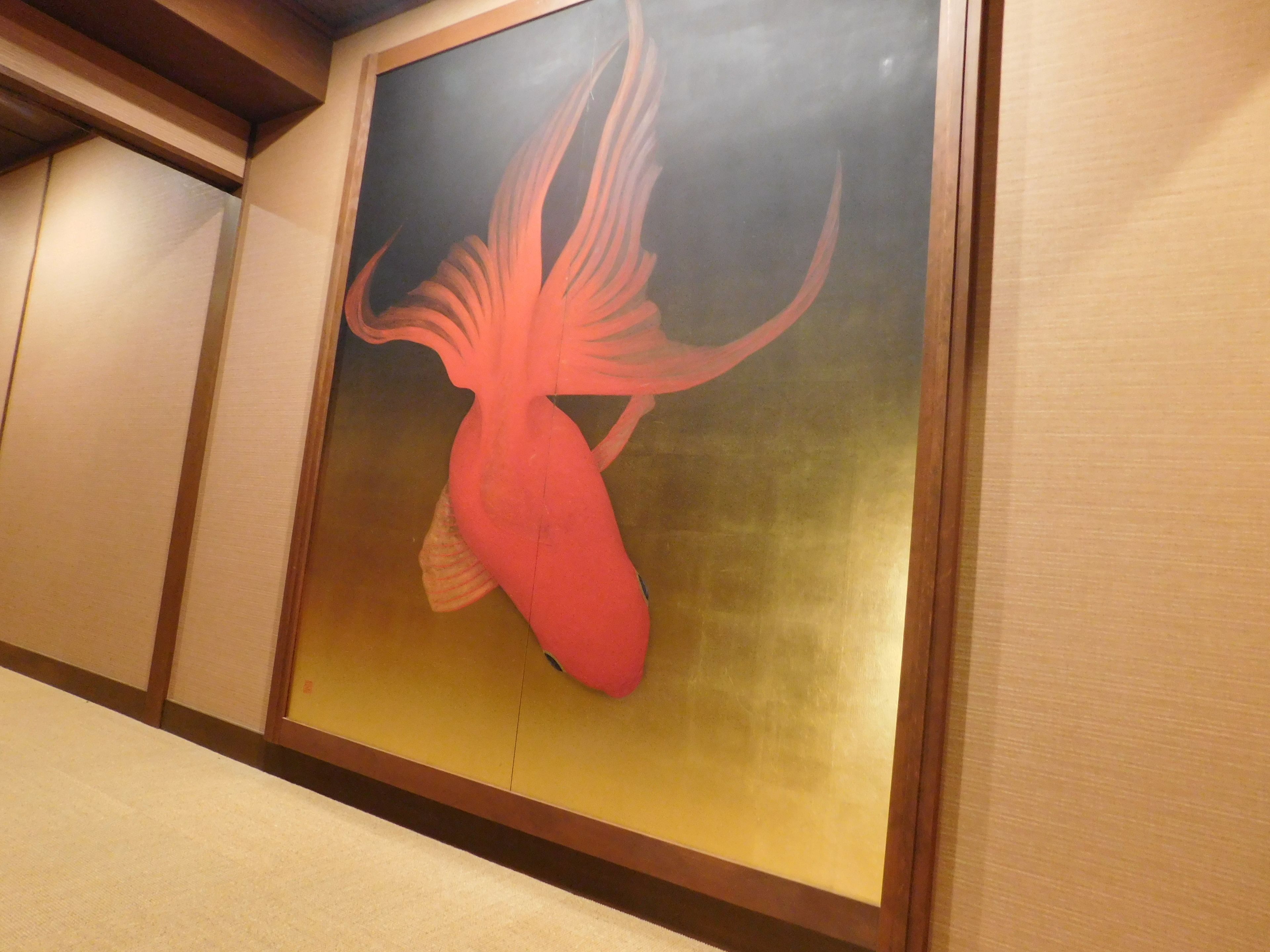 A wall with a framed artwork of a stylized fish.
