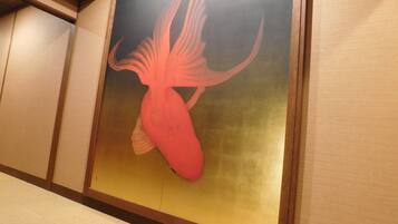 A wall with a framed artwork of a stylized fish.