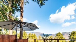 Una terraza con mobiliario exterior, una chimenea y una valla de madera.