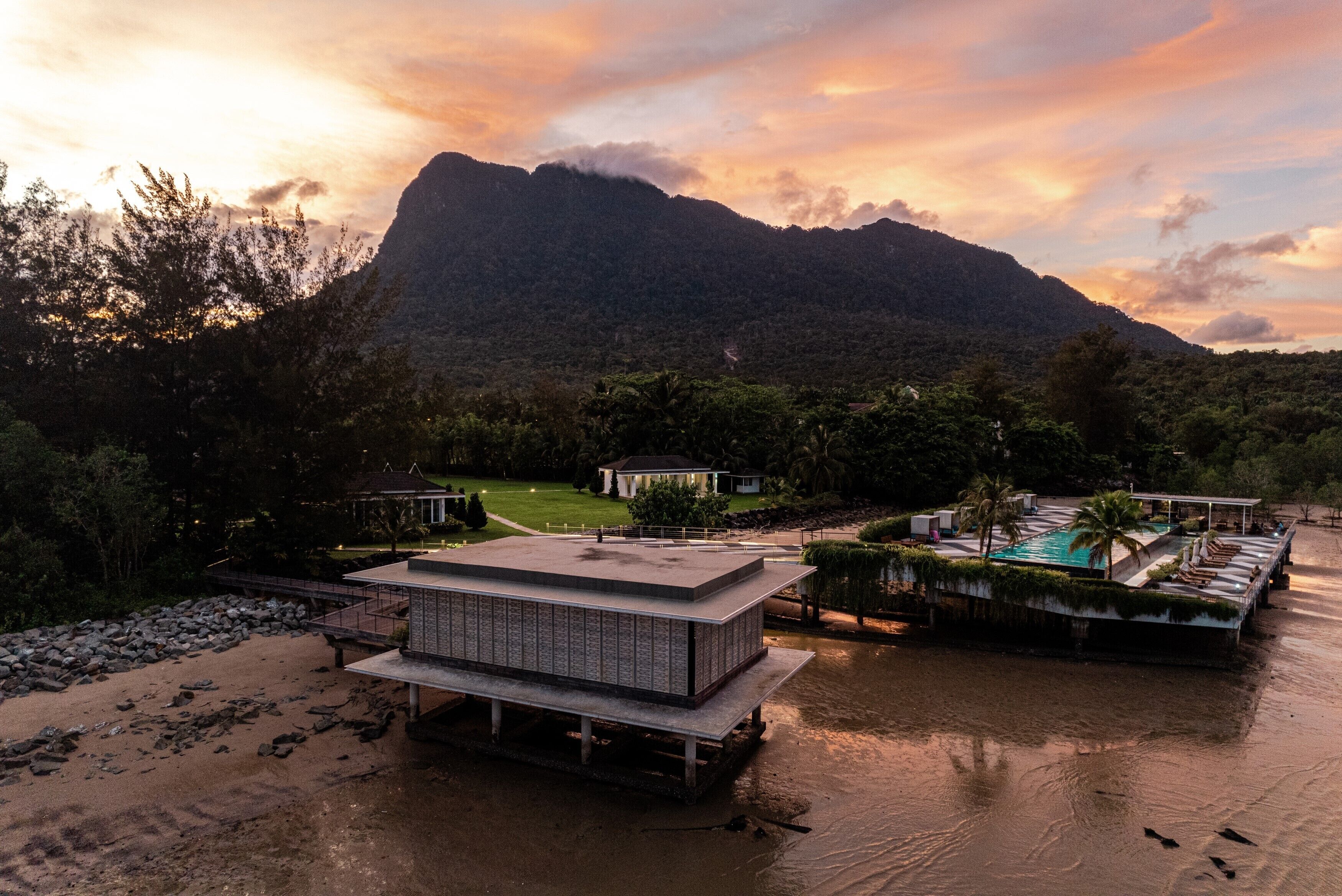 A resort with a pool, a large building, and a mountain in the background.