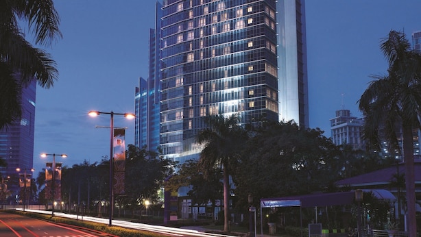 A tall, modern hotel with a prominent sign at the top. - Oakwood Premier Cozmo Jakarta (Jakarta)