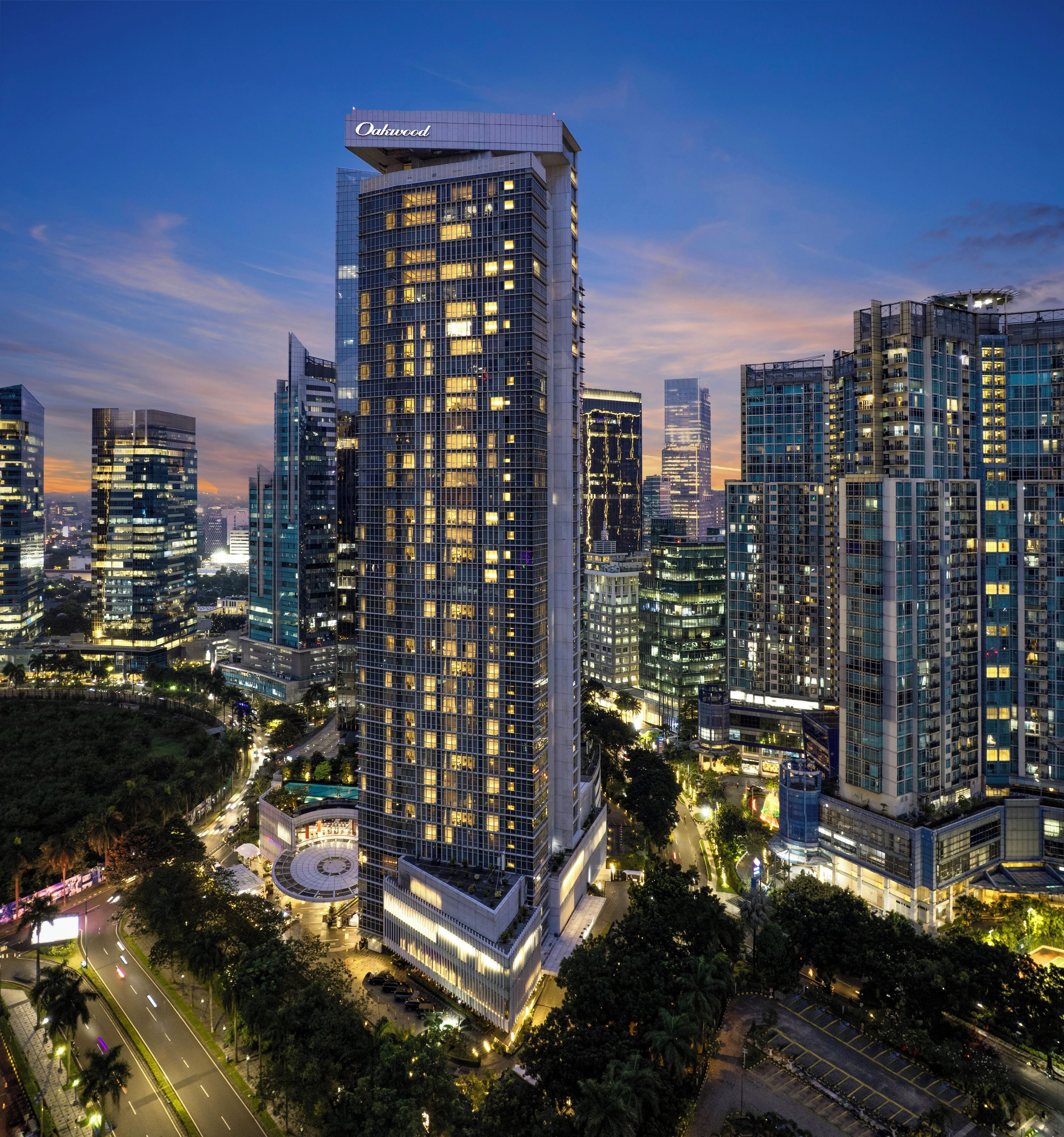 A high-rise building with a modern glass facade, surrounded by other high-rise buildings in a cityscape.