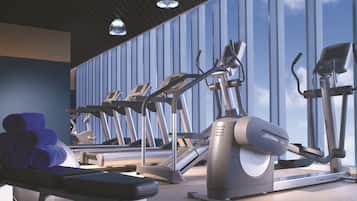 A gym with treadmills, ellipticals, and a bench.