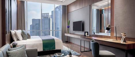 A modern hotel room with a large bed, a desk, a chair, and a TV.