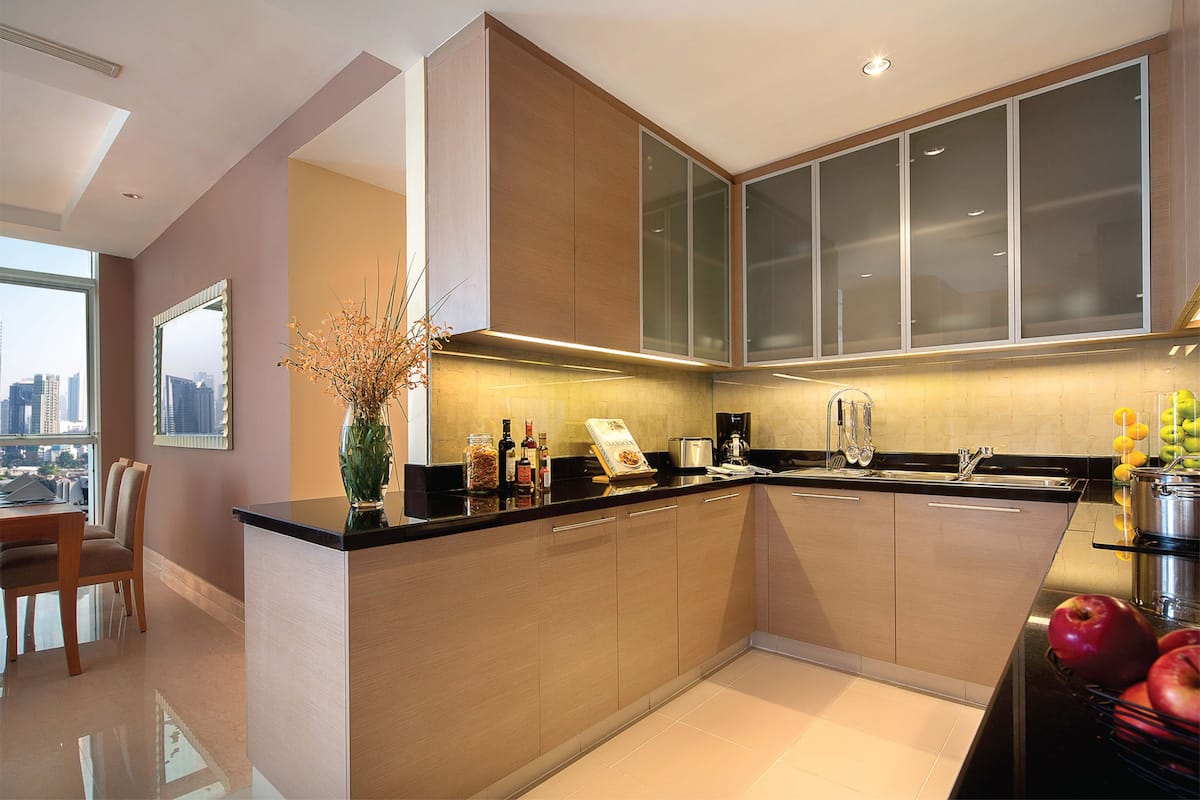 A modern kitchen with a central island, built-in cabinets, and a large window offering a city view.