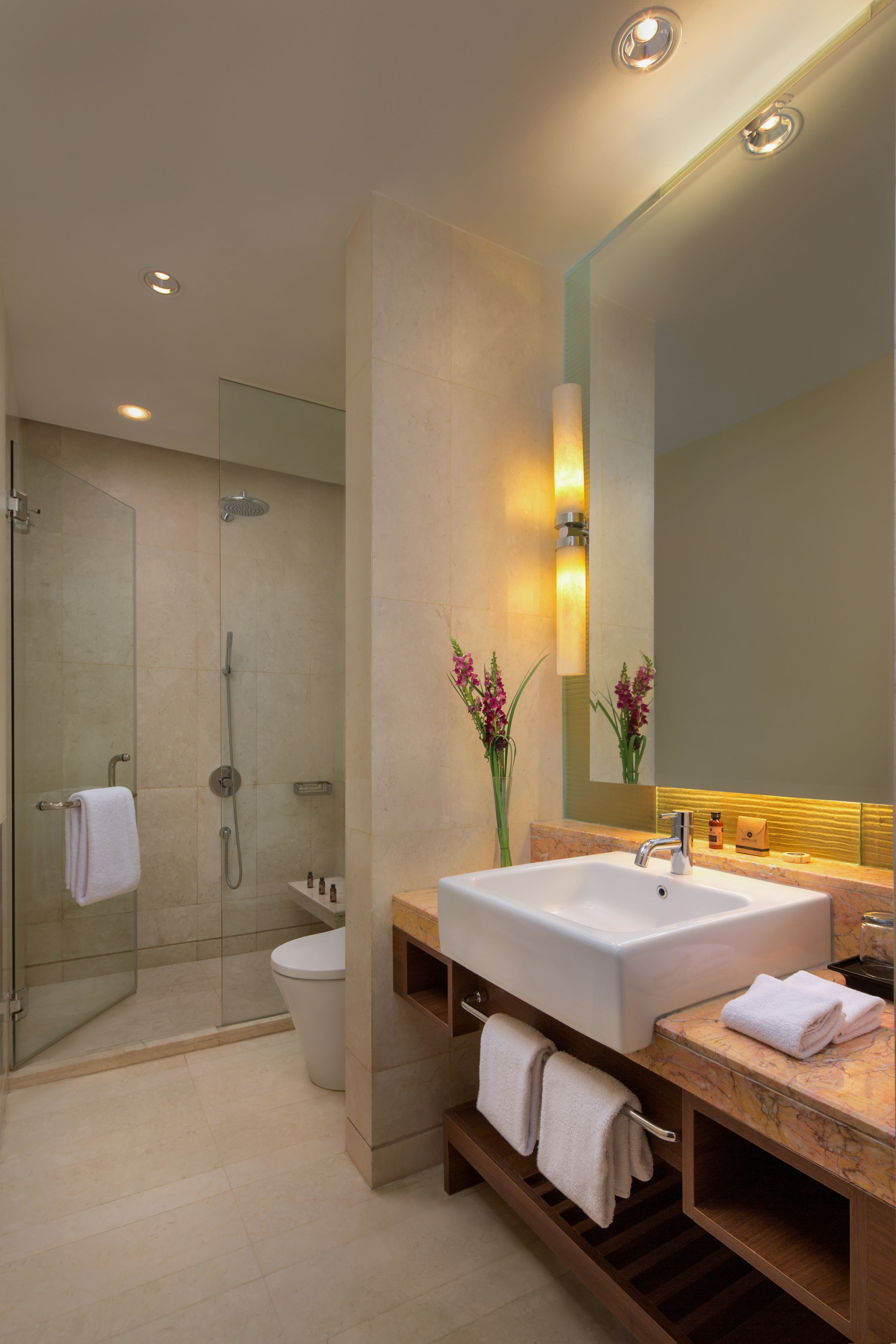 A modern bathroom with a large sink, mirror, and shower.