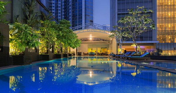 Una piscina al aire libre, tumbonas