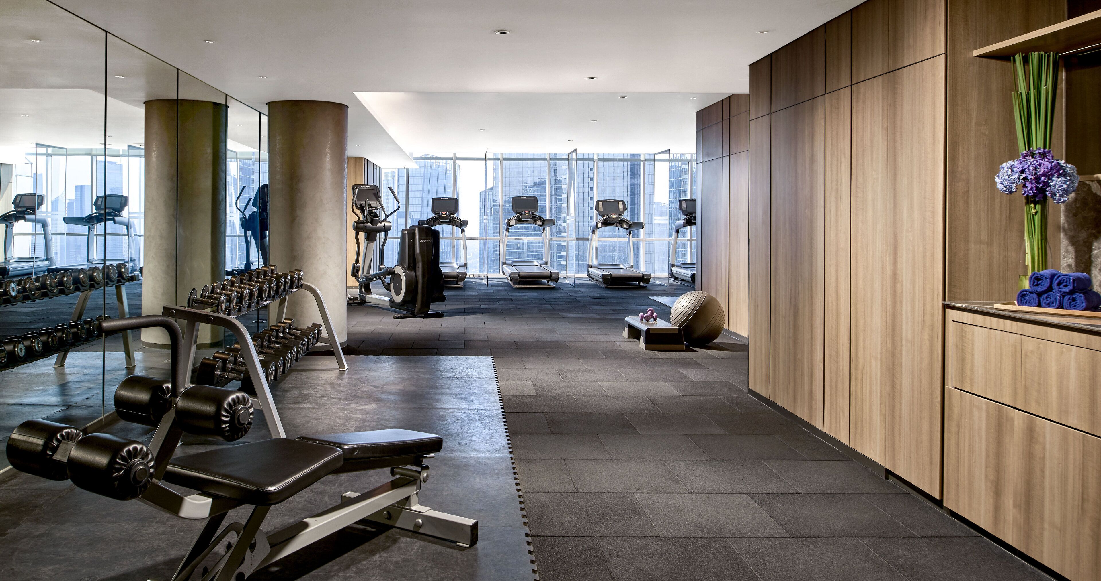Una palestra moderna con attrezzature cardio, macchinari per pesi e una panca.