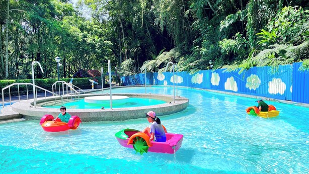 A swimming pool with multiple water slides and a surrounding fence. - Uni-Resort Mawutu (Guanxi)