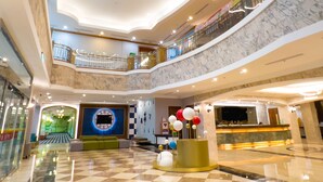A multi-level atrium with a checkered floor, a reception desk, and a decorative centerpiece with spherical ornaments. - Uni-Resort Mawutu (Guanxi)