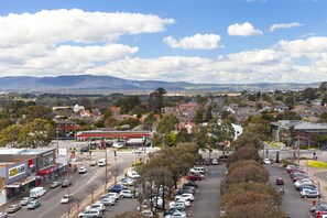 A parking lot with cars, a gas station, and buildings in the background. - Park Avenue - IKON Glen Waverley (Glen Waverley)