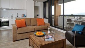 A modern living room with a sofa, coffee table, and a view of the city. - Park Avenue - IKON Glen Waverley (Glen Waverley)