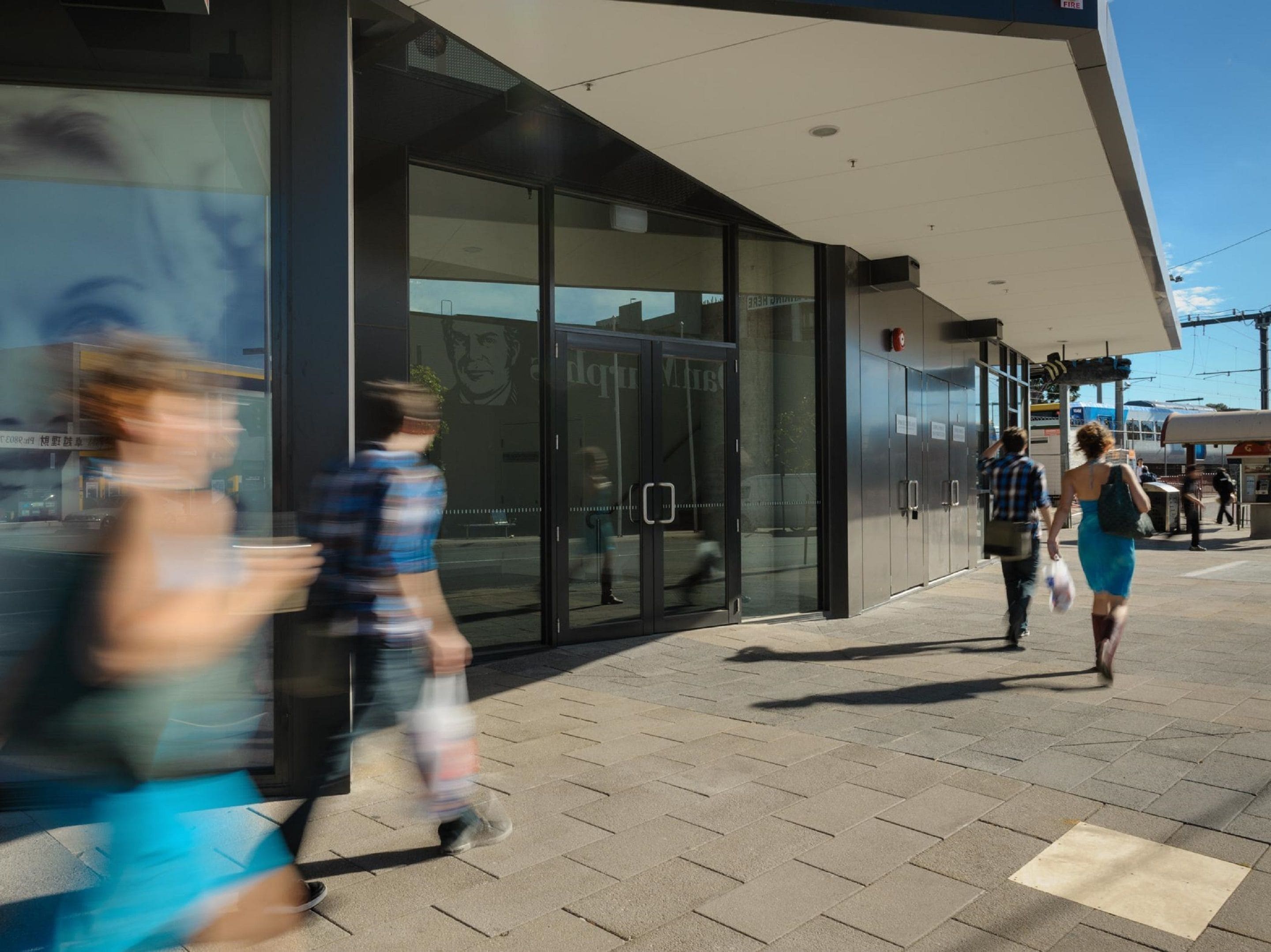 A modern building with large glass doors and a metal facade.