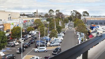 A busy urban street with parked cars and buildings.