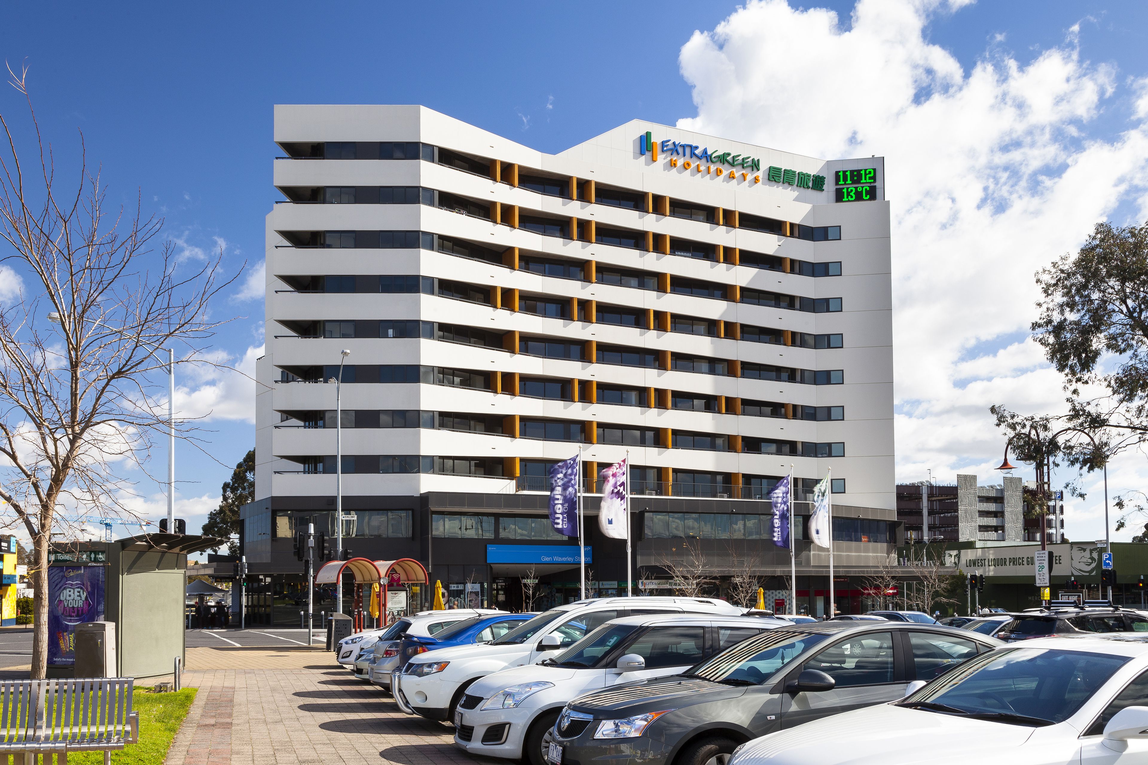 A multi-story hotel with a modern design, featuring balconies and large windows.
