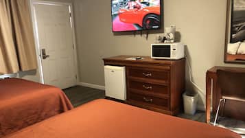 Habitación de hotel con dos camas, un televisor montado en la pared, un refrigerador pequeño y un cuadro decorativo.
