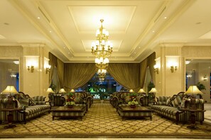 A spacious lobby with a grand chandelier, plush seating, and a view of the cityscape. - Eldora Hotel (Hue)