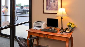 A hotel reception desk with a computer, printer, and telephone.