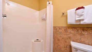 A bathroom with a shower, toilet, and towel rack.