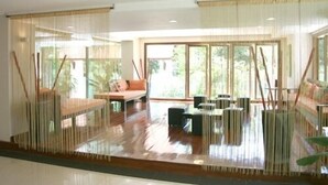 Una habitación amplia con un gran ventanal, un sofá, una mesa baja y un comedor.
