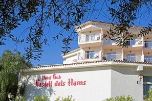 Hotelli nimeltä ”Hotel Club Castel dels Hams”, jossa on valkoinen julkisivu ja parvekkeet.