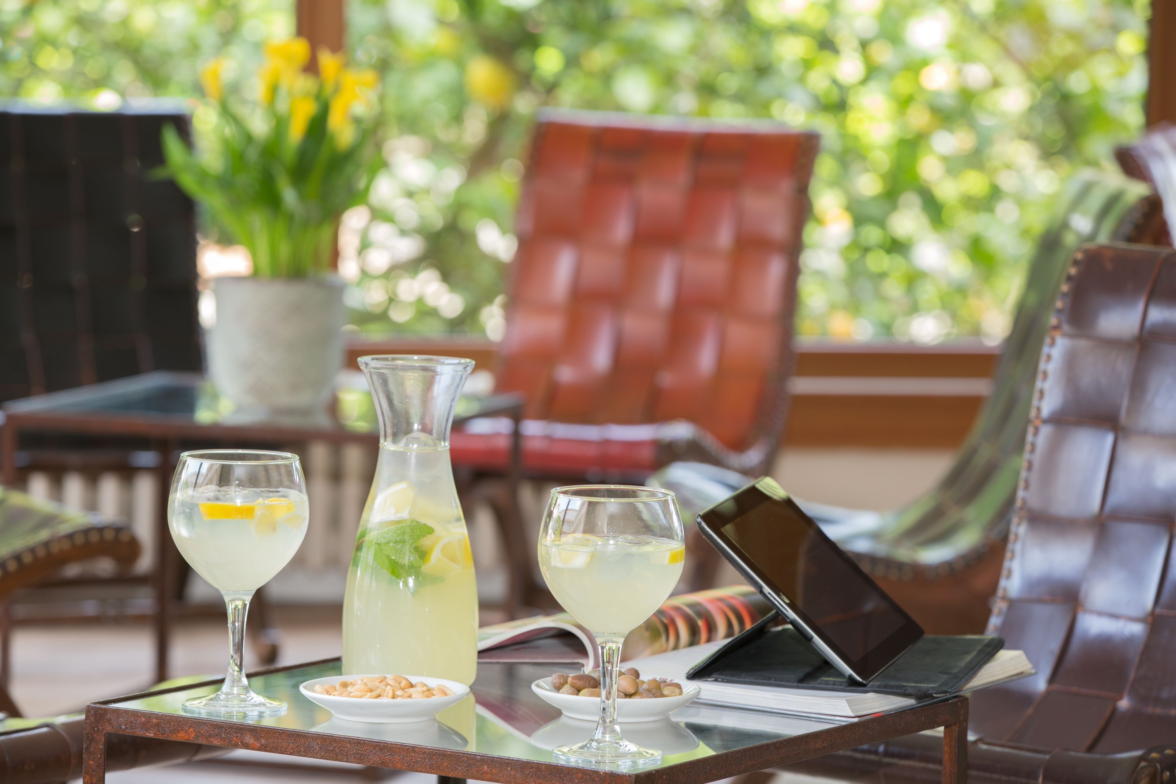 A table with two glasses of a clear beverage, a pitcher, and a laptop.