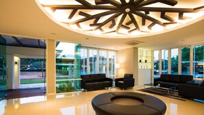 Un interior moderno con una zona de estar circular, ventanas amplias y un diseño de techo original.