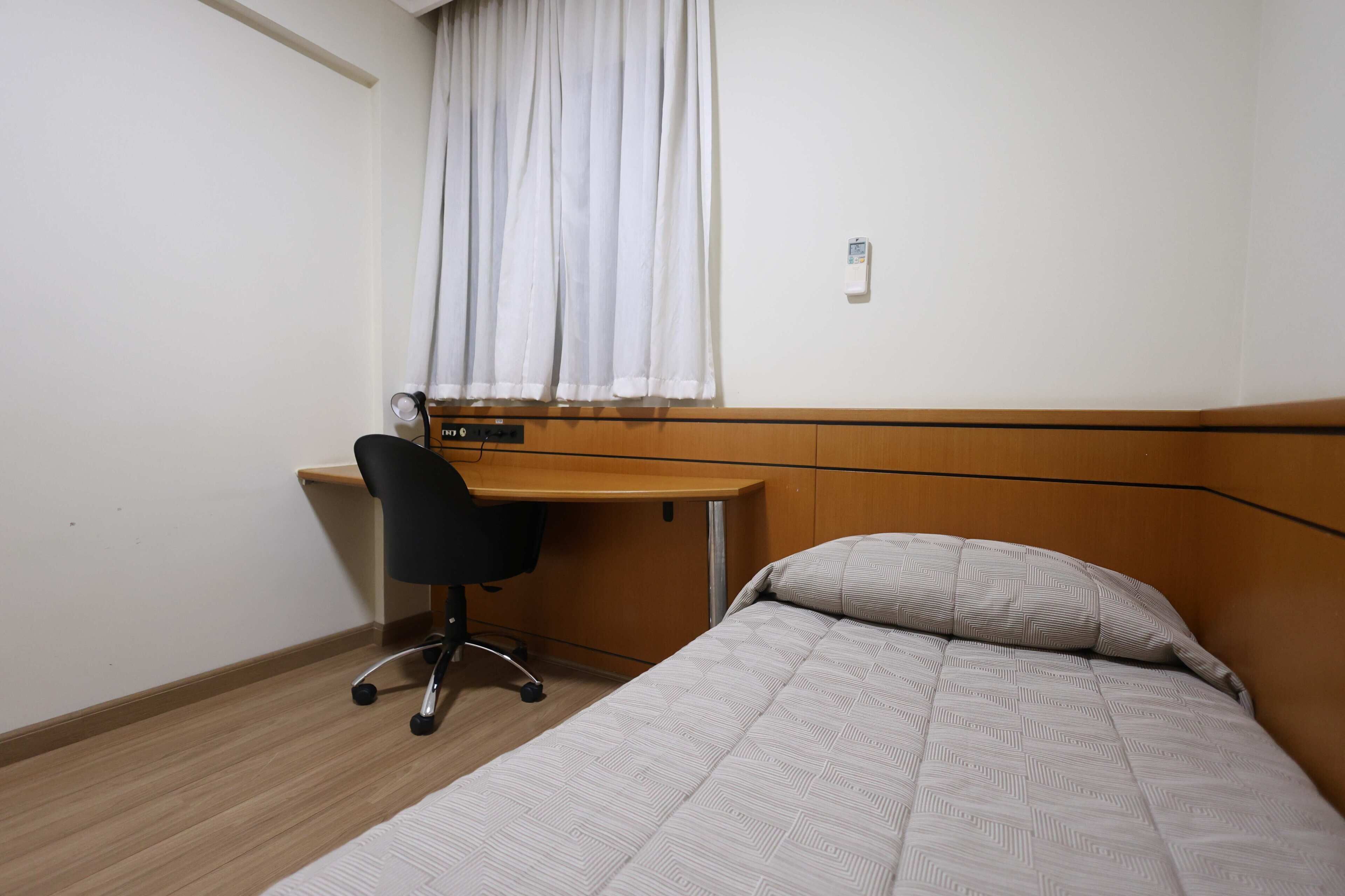 Ein Hotelzimmer mit einem Bett, einem Schreibtisch und einem Sessel.