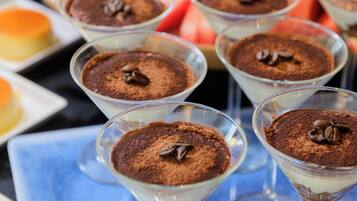 Una mesa con vasos de postres: tiramisú, sandía y uvas.