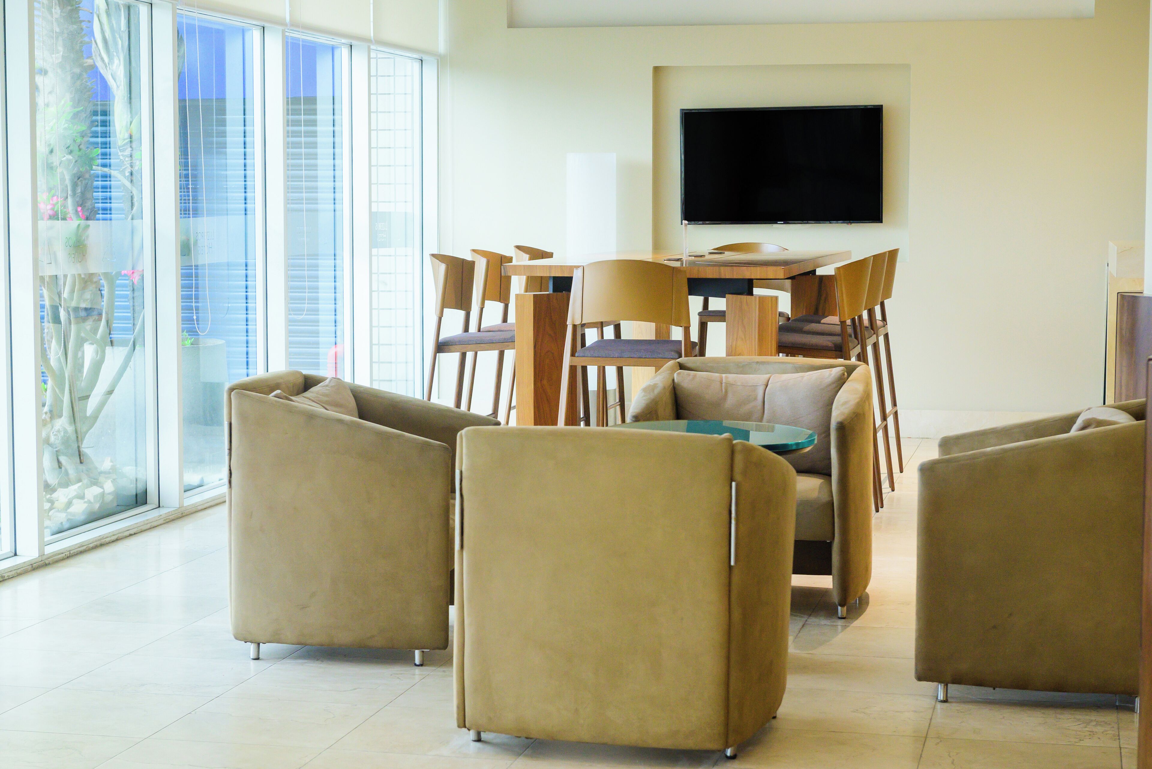 Una sala de estar moderna con un televisor grande, sofás cómodos y un comedor con sillas.
