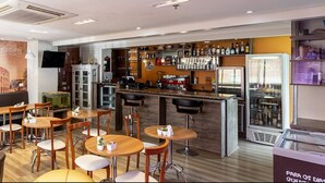 Ein Restaurant mit Barbereich, Tischen, Stühlen und einem Wandgemälde des Kolosseums.