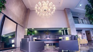 Eine Lobby mit einer Chandelüster, einer Sitzecke und einem Empfangsbereich.