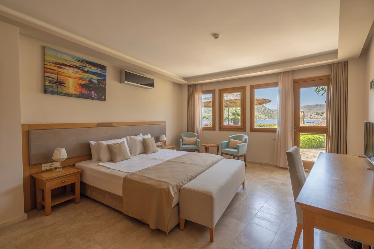 Ein Hotelzimmer mit einem großen Bett, Nachttischen, einem Schreibtisch und zwei Stühlen.
