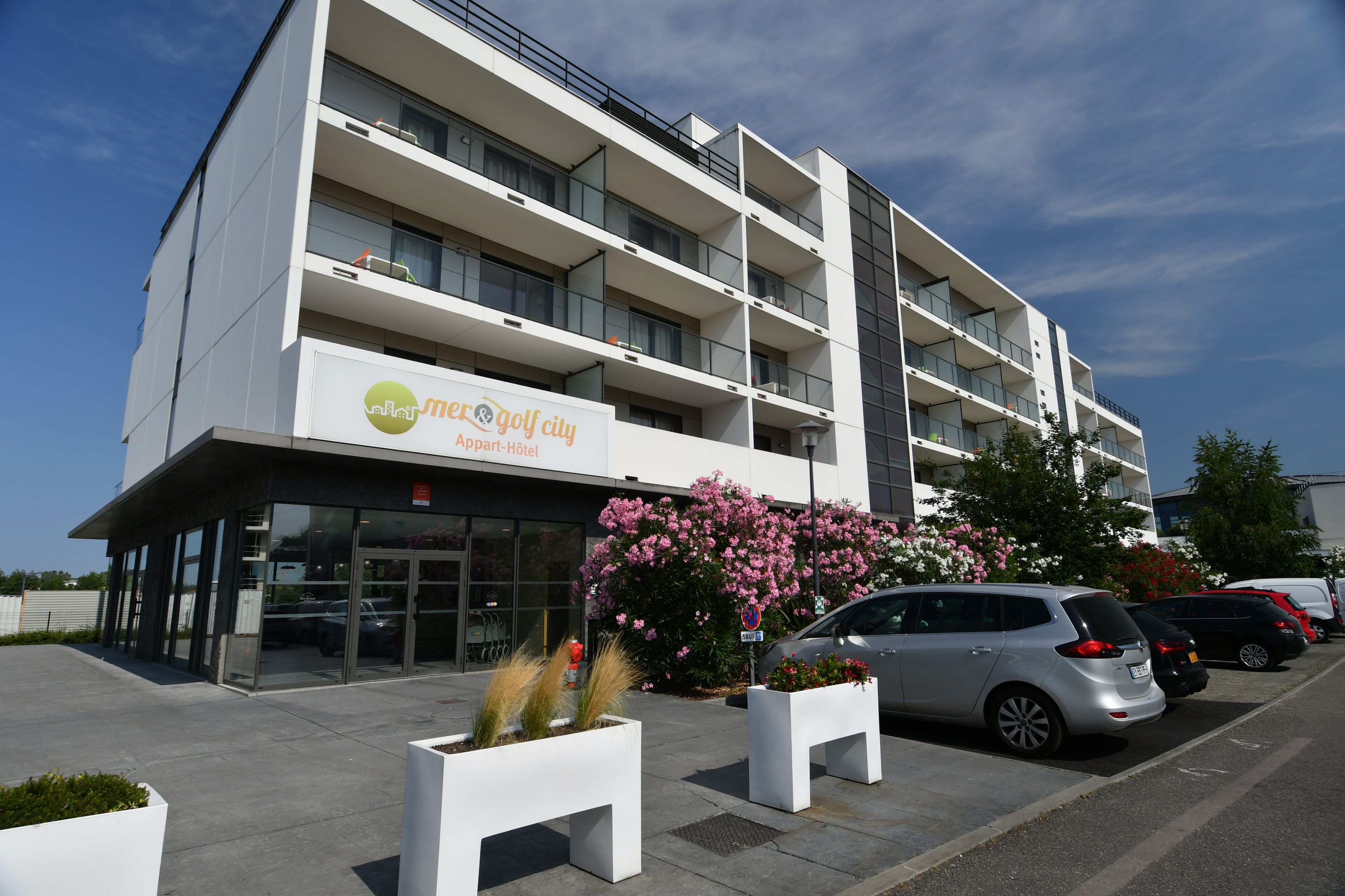 Un edificio moderno con un cartel que dice 'Villas Moser Golf City Apartment Hotel'.