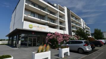 A modern building with a sign for 'Villas Moser Golf City Apartment Hotel'.