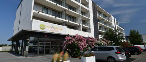 Un edificio moderno con un cartel que dice 'Villas Moser Golf City Apartment Hotel'.